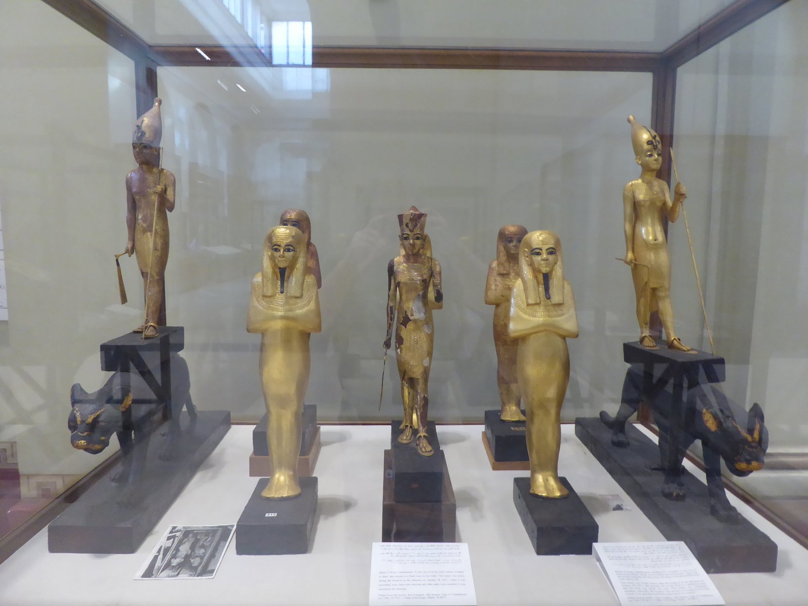 Statuettes et objets anciens présentés dans une vitrine de musée