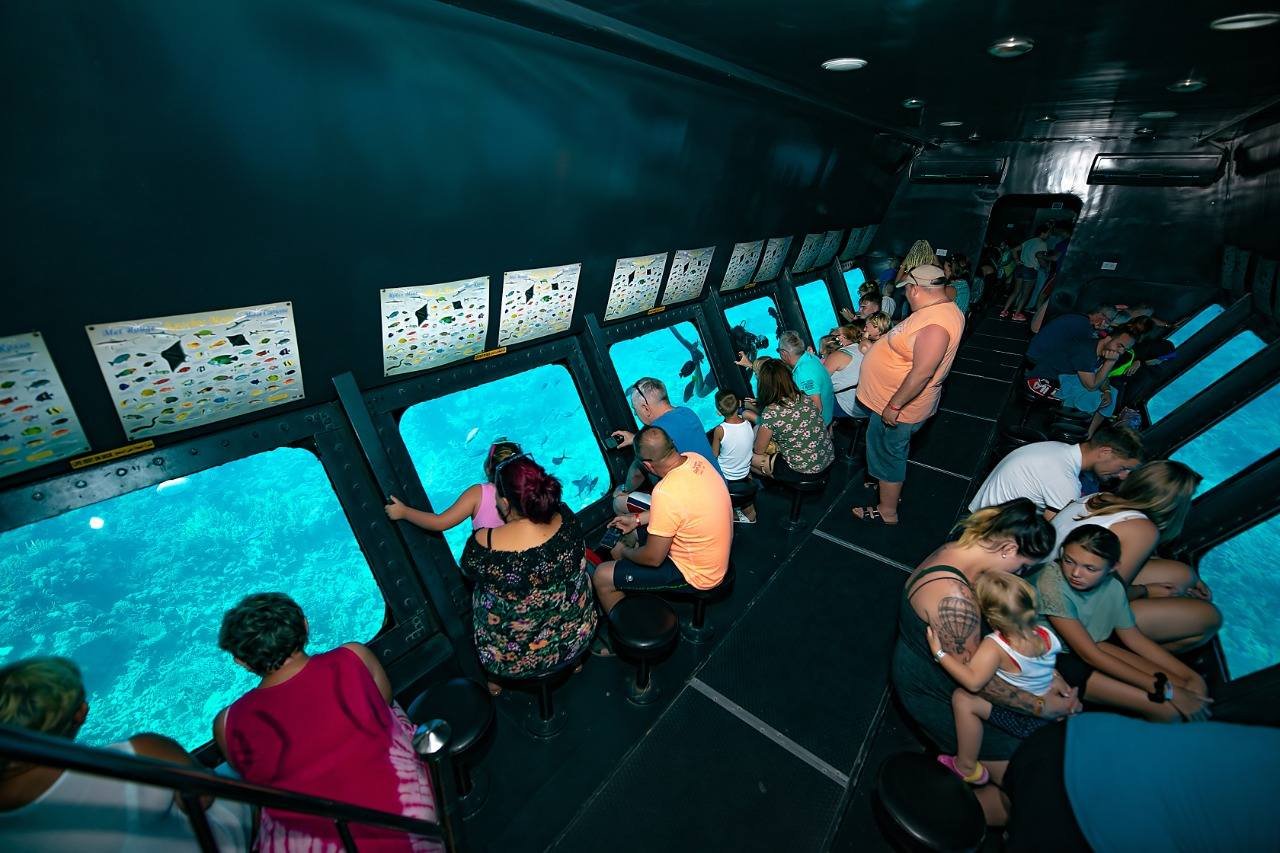 Passengers sitting beside the underwater cabin windows