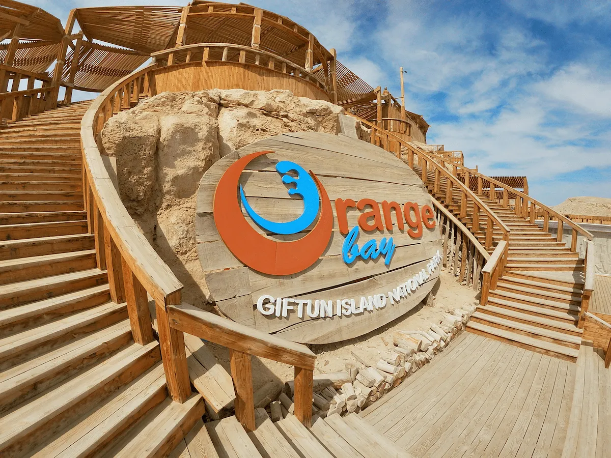 Orange Bay sign and beach steps when planning the best time to visit Orange Bay Hurghada