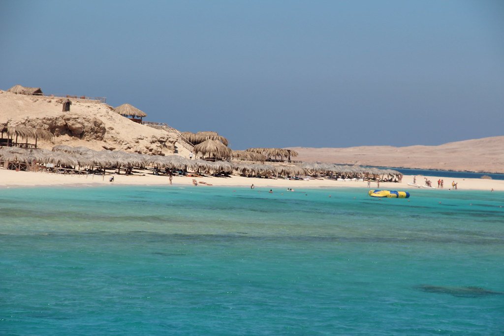 Rivage de Paradise Island avec mer turquoise et relief désertique