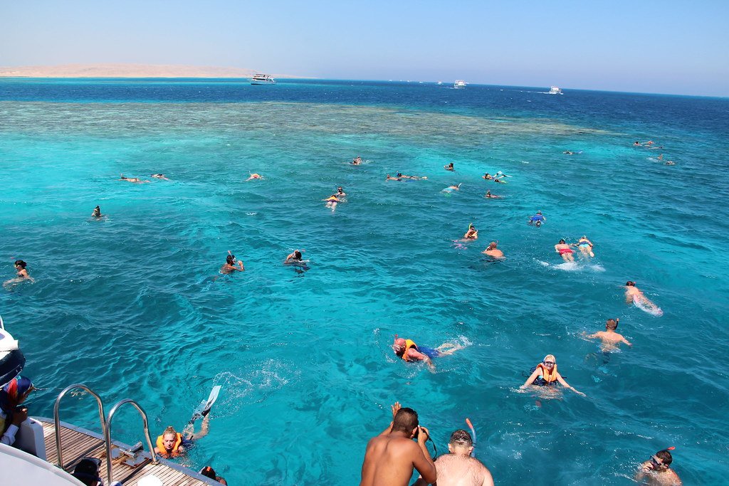 Voyageurs faisant du snorkeling près d’un bateau en mer Rouge
