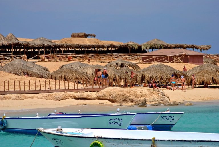 Strand mit Sonnenschirmen und kleinen Booten am Ufer