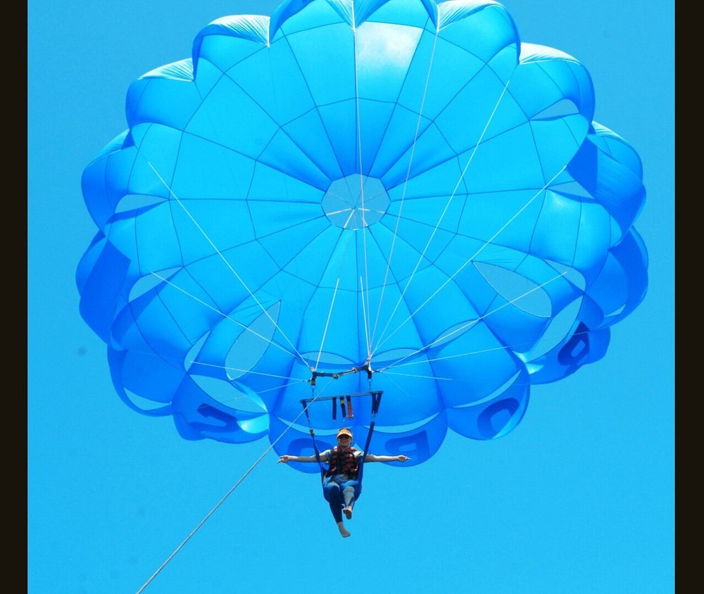 Participant sous une voile bleue de parachute ascensionnel