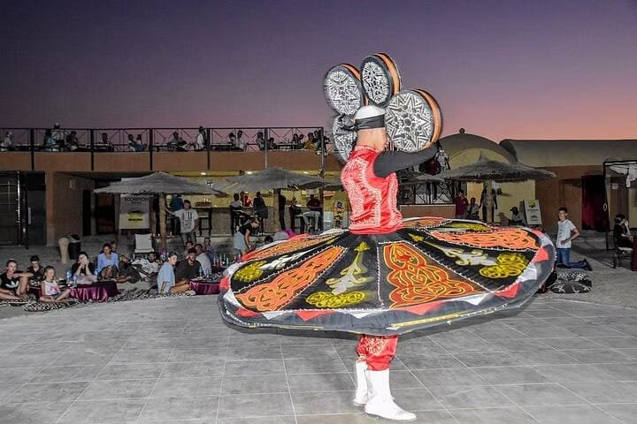 Tanoura-Tänzer mit farbigem Rock bei einer Show im Wüstencamp