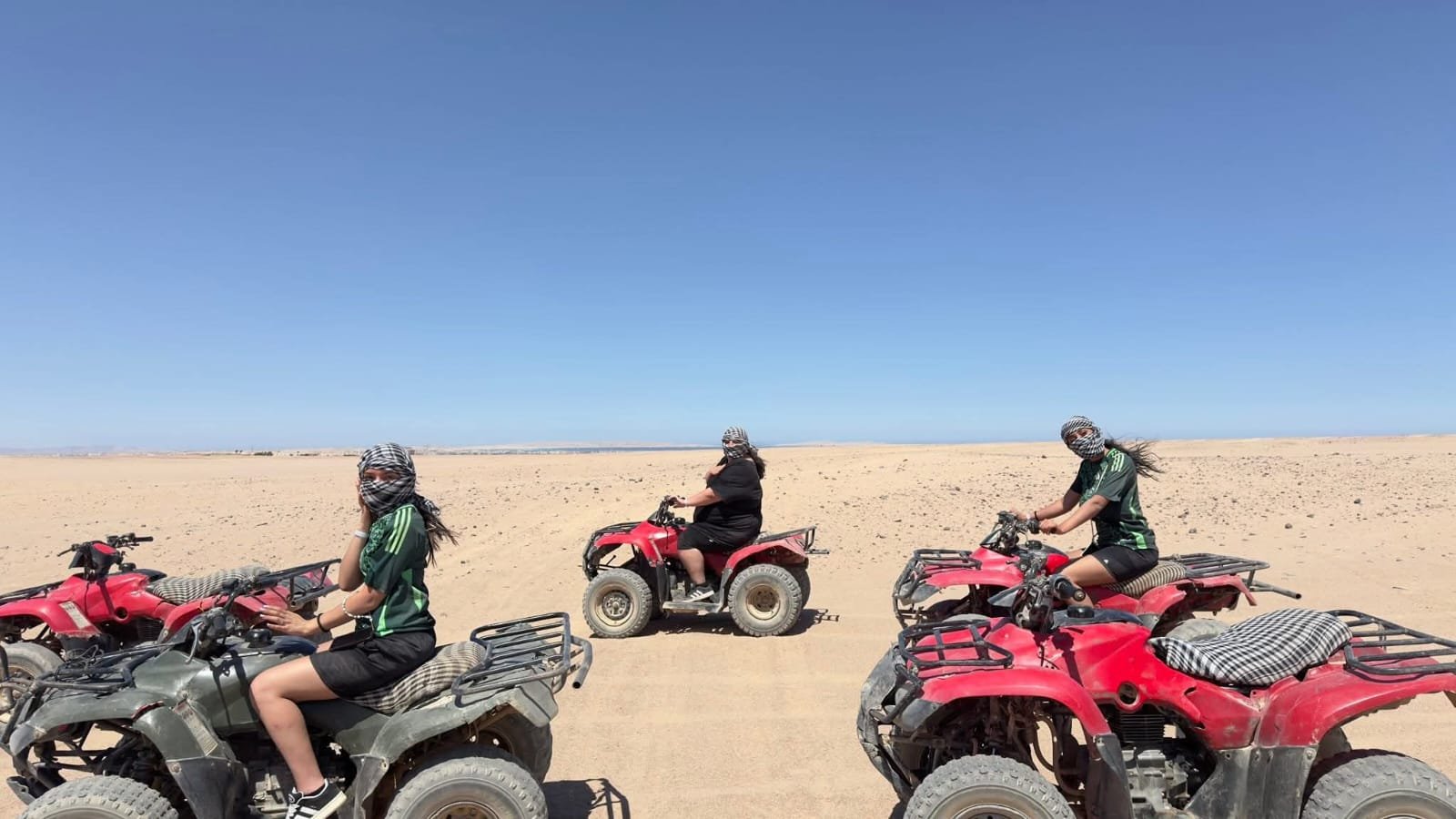 Mehrere Gäste auf roten Quads in der Wüste