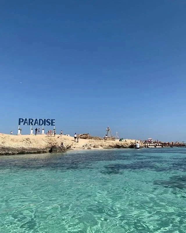 Shallow water beside the Paradise Island shoreline sign