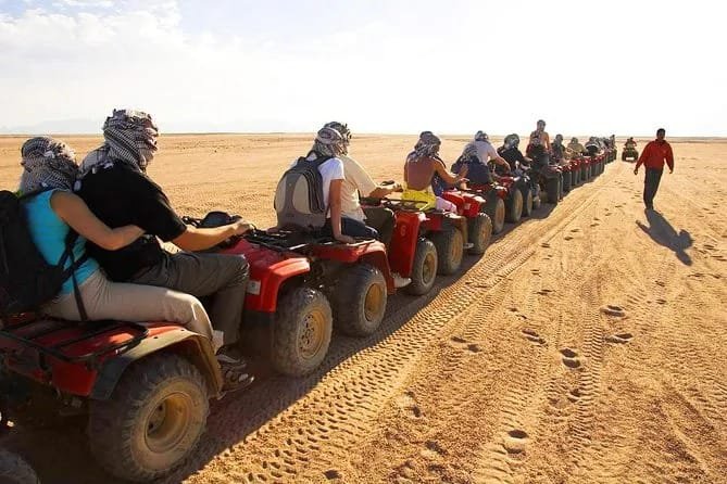 Tourists riding quad bikes on a Hurghada desert safari with safety equipment