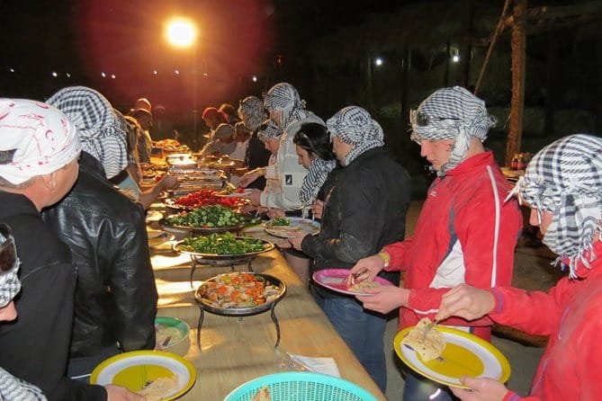 Guests sharing an evening meal at a desert excursion camp