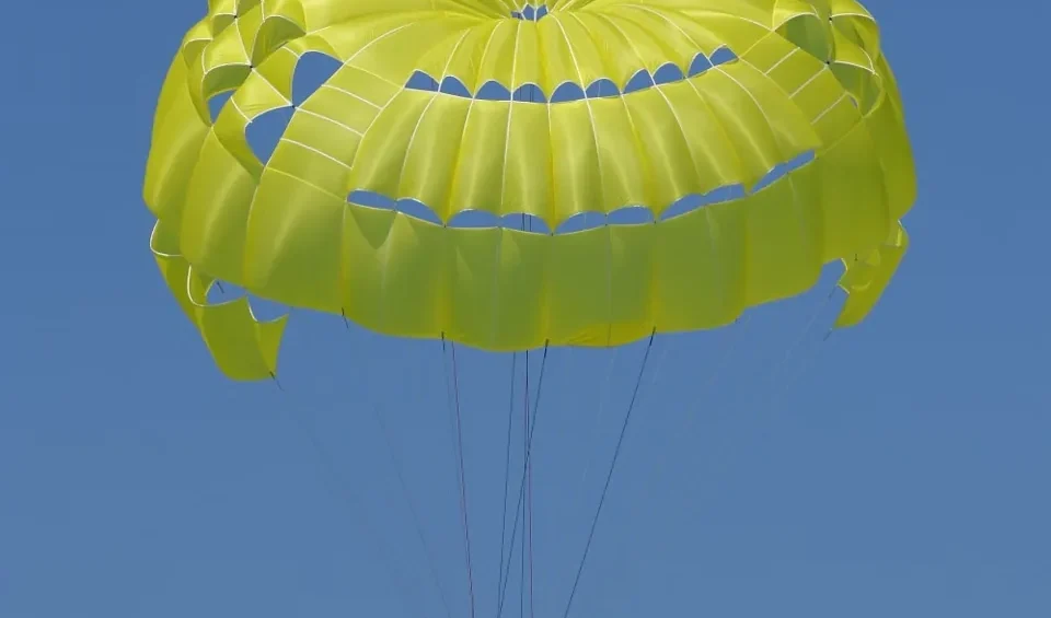 Participant suspended beneath a yellow parasail canopy