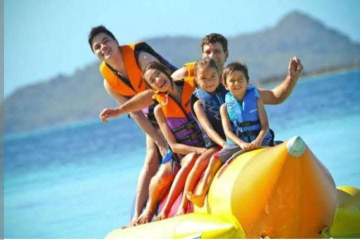 Family wearing life jackets on an inflatable banana boat