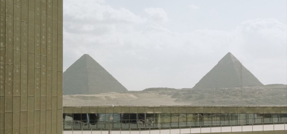 Pyramids of Giza seen through the Grand Egyptian Museum architecture