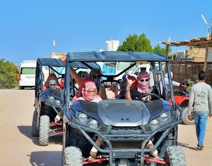 Visitors seated in buggies at a desert safari base