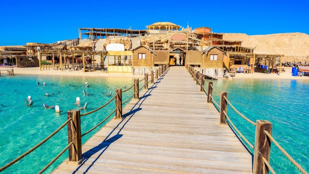 Holzsteg über türkisfarbenem Wasser zur Insel Orange Bay in Hurghada