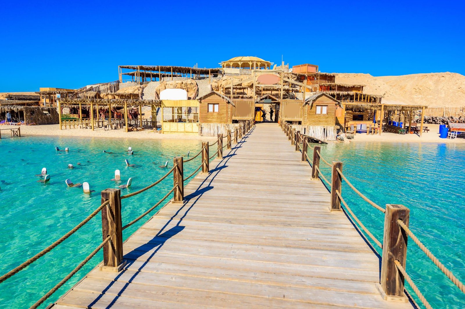 Holzsteg mit Blick auf die Strandgebäude von Orange Bay Hurghada