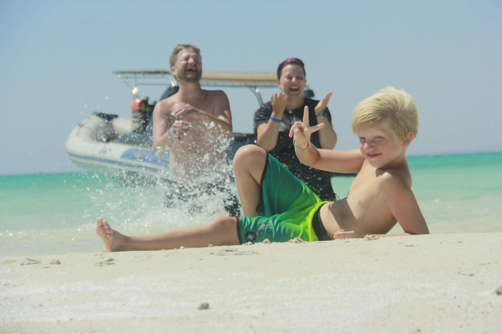 Kinder und Erwachsene am flachen Ufer neben einem Speedboot