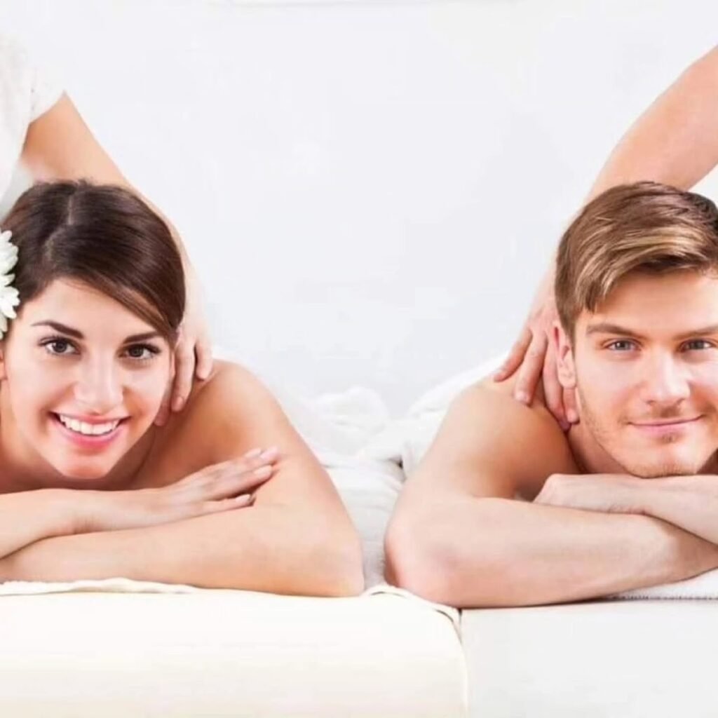 Ein Paar liegt nebeneinander auf zwei Massageliegen – Symbolfoto